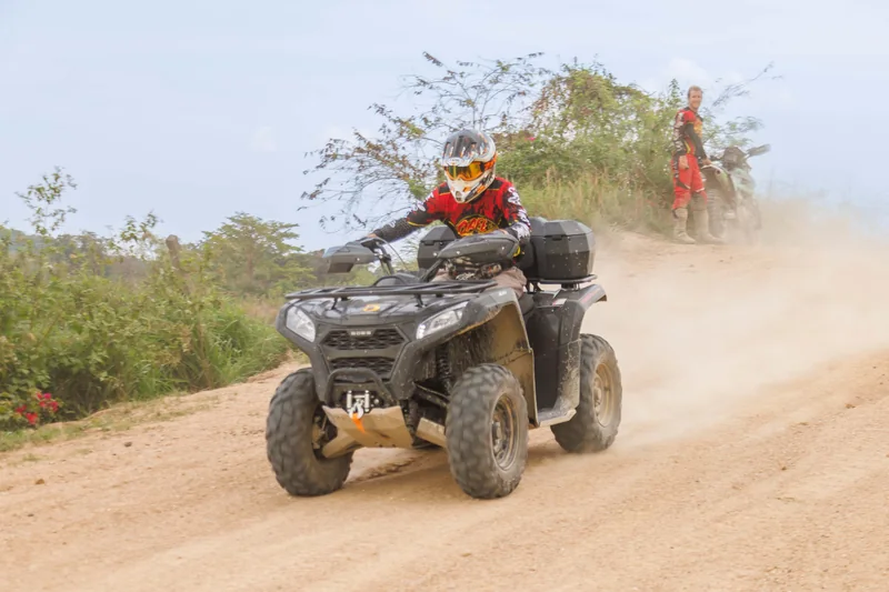 ATV rider travelling through dust on a dirt trail