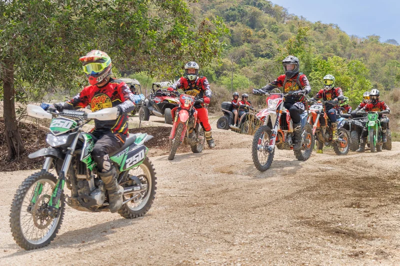 Group of dirt bike riders moving down a rocky trail